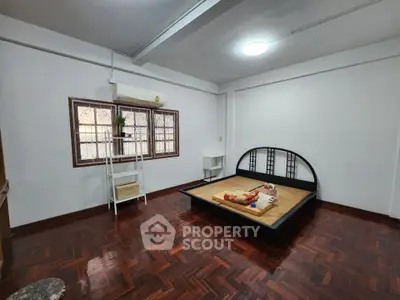 Spacious bedroom with wooden flooring and minimalist decor