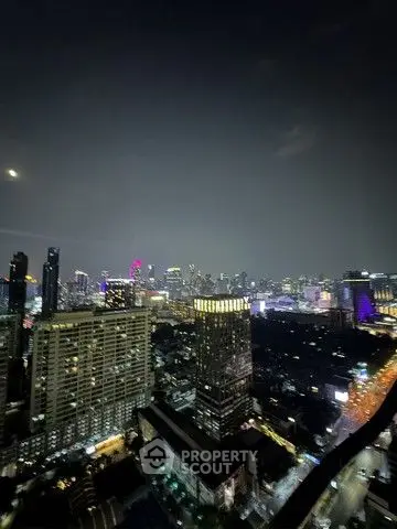 Stunning cityscape view from high-rise building at night with vibrant city lights.