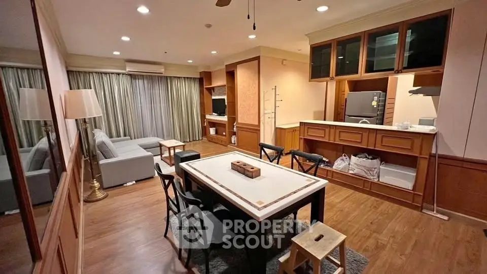 Spacious open-layout living room with modern kitchen and elegant wood finishes.