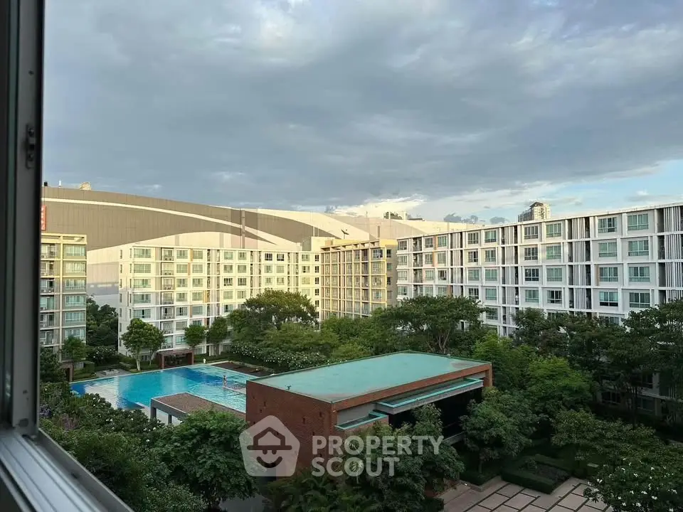 Stunning view of modern apartment complex with lush gardens and inviting pool area.