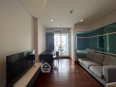 Modern living room with sleek furniture and large window offering city view.