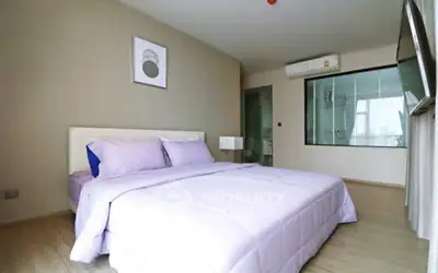 Spacious modern bedroom with elegant decor and large window for natural light.