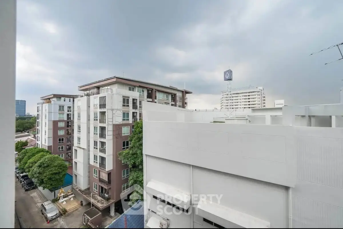 Urban apartment buildings with cloudy sky view, showcasing city living.