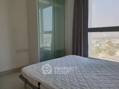 Bright bedroom with large window offering stunning city views, featuring a comfortable bed and modern decor.