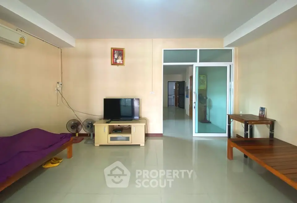 Spacious living room with modern TV setup and minimalist furniture