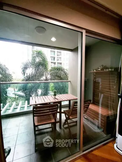 Charming balcony with wooden furniture and lush greenery view in modern apartment