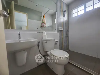 Modern bathroom with sleek fixtures and large mirror in a contemporary home.