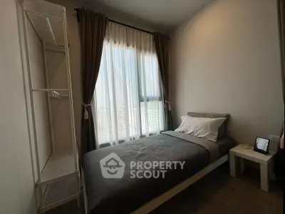 Cozy bedroom with single bed and natural light from large window