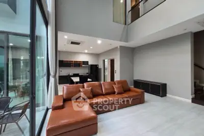 Spacious modern living room with high ceilings and elegant leather sofa in luxury home.