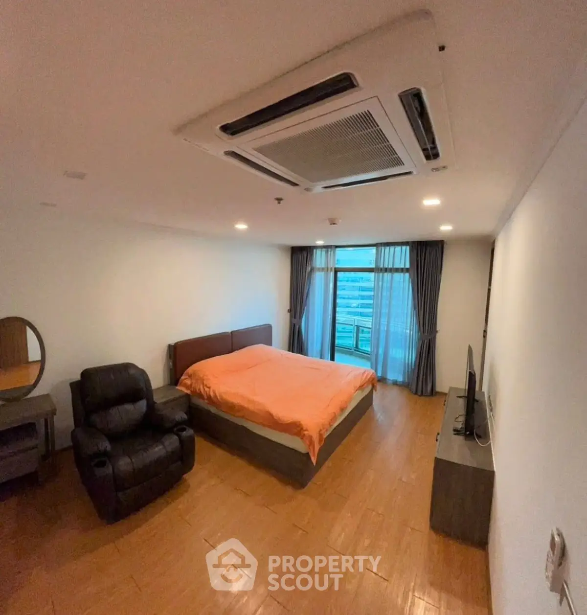 Spacious bedroom with modern furnishings and large window view