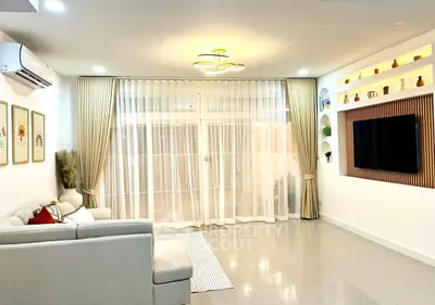 Spacious modern living room with elegant decor and large windows for natural light.