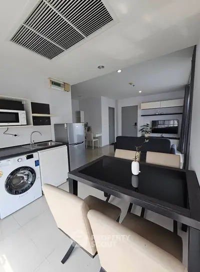 Modern open-plan kitchen and dining area with sleek appliances and stylish furniture.