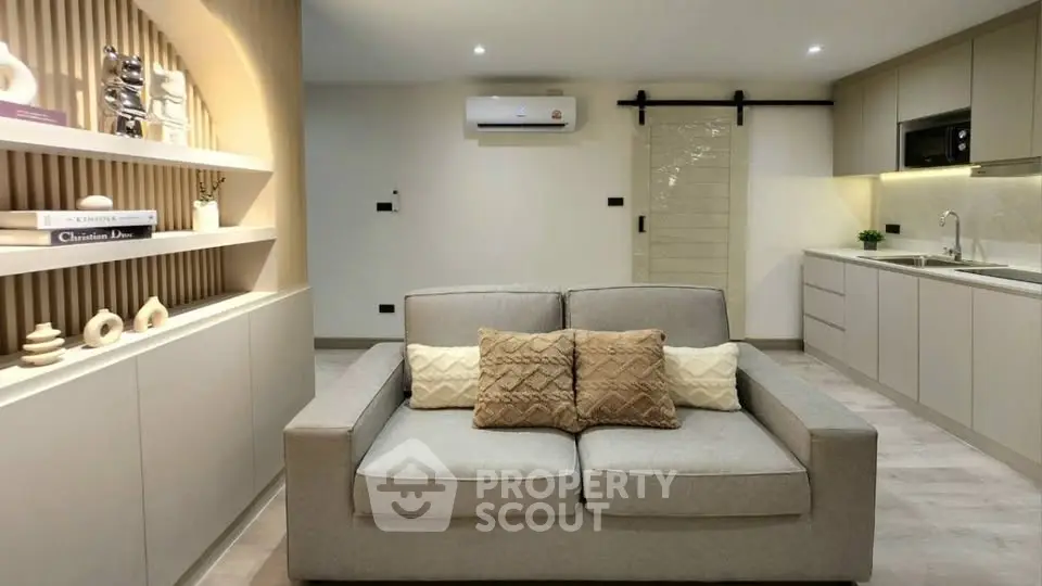Modern living room with cozy sofa and stylish kitchen in open layout apartment.