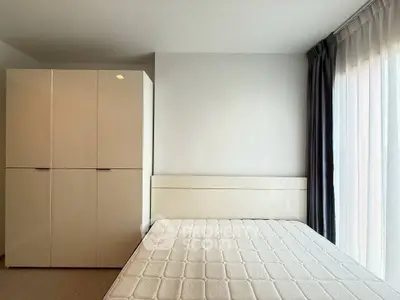 Modern bedroom with large wardrobe and natural light from floor-to-ceiling window.