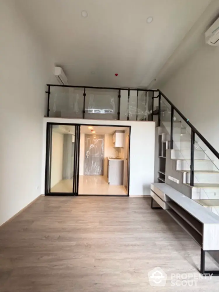 Modern loft-style apartment with mezzanine and sleek glass railing