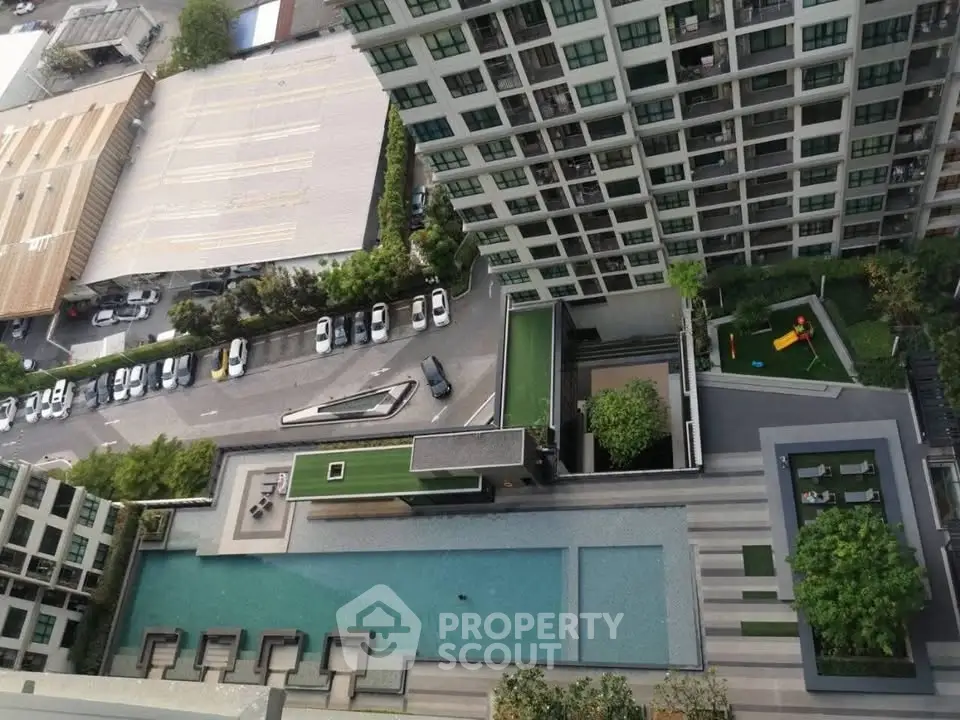 Stunning aerial view of modern apartment complex with pool and lush greenery, perfect for urban living.