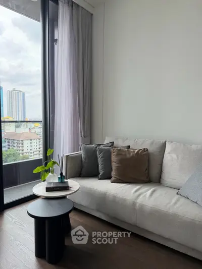 Modern living room with cozy sofa and city view from large window, perfect for urban living.