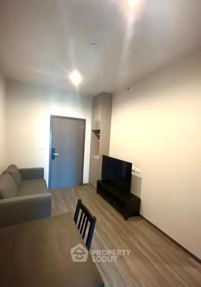 Modern living room with sleek furniture and wooden flooring in a cozy apartment.