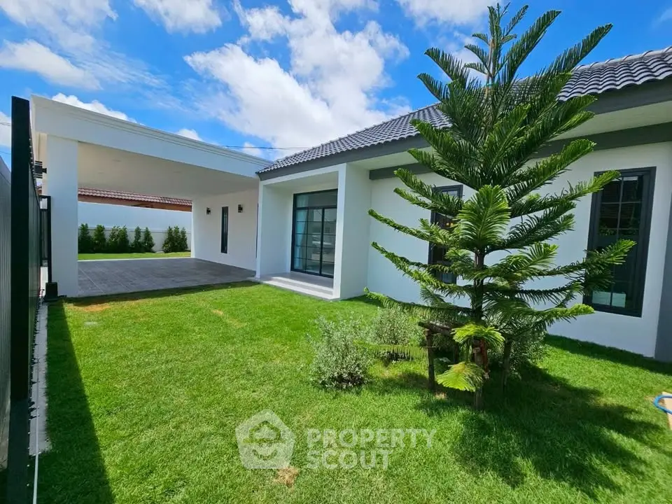 Charming modern home with lush green garden and spacious patio, perfect for outdoor relaxation.