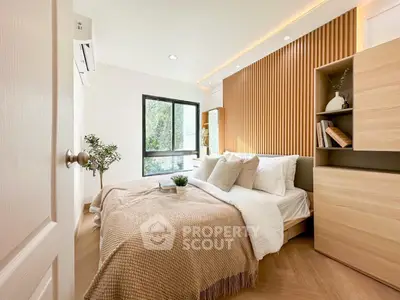Modern bedroom with cozy decor and natural light, featuring wooden accents and stylish furnishings.