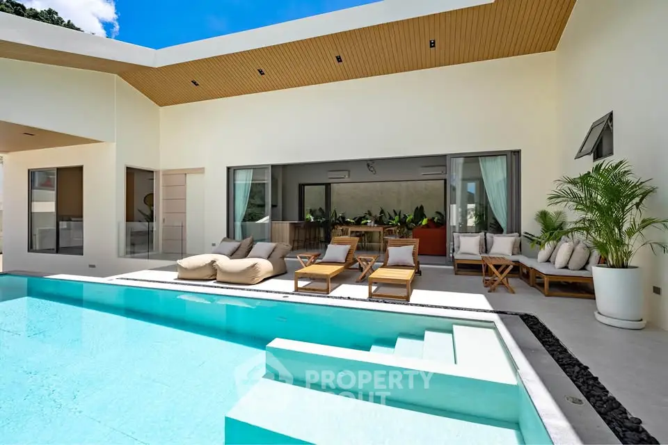 Luxurious modern villa with private pool and spacious outdoor seating area, perfect for relaxation and entertainment.