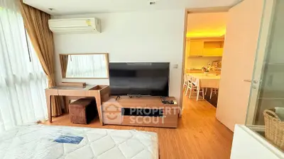 Modern bedroom with TV and open kitchen layout in a stylish apartment