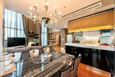 Luxurious open-layout living and dining area with elegant chandelier and modern kitchen.