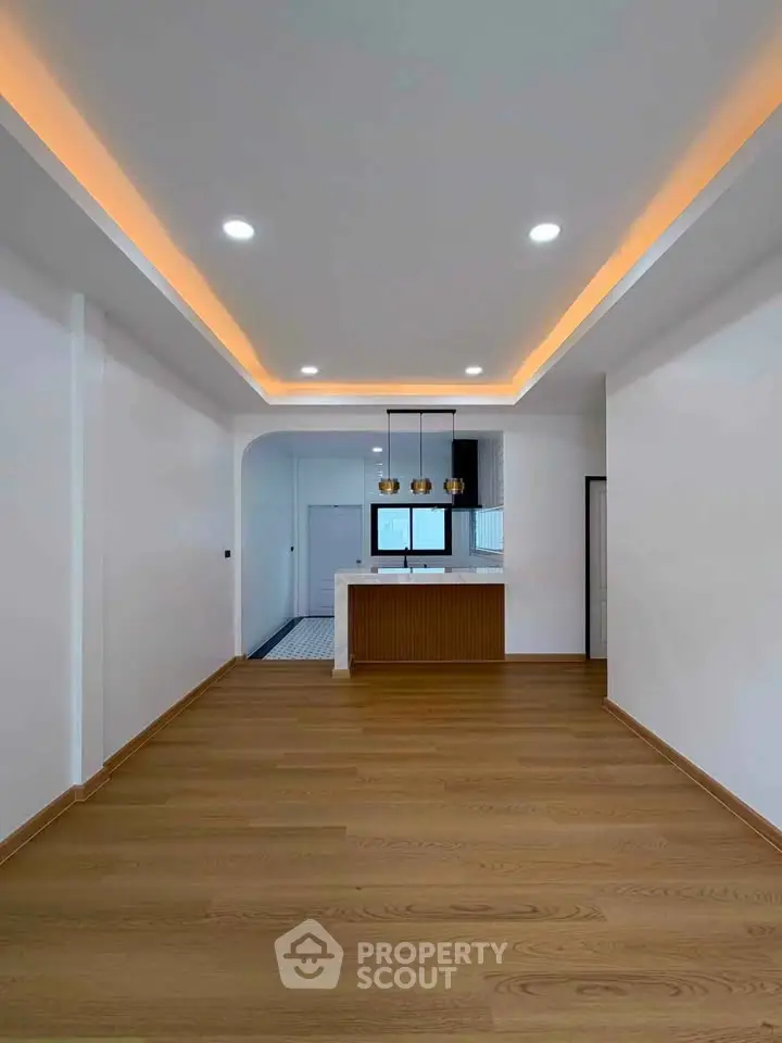 Modern open-plan living room with stylish lighting and wooden flooring