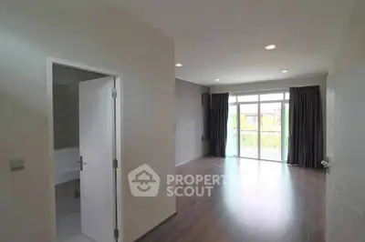 Spacious modern living room with large windows and hardwood floors, perfect for natural light lovers.