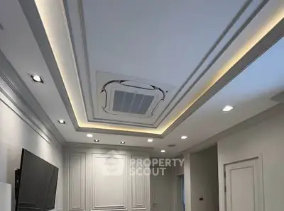 Modern living room with recessed lighting and ceiling air conditioning unit.