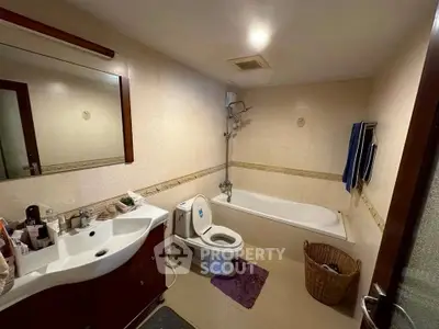 Spacious bathroom with modern fixtures and bathtub in a cozy apartment.