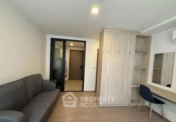 Modern living room with sleek furniture and wooden flooring in a contemporary apartment.