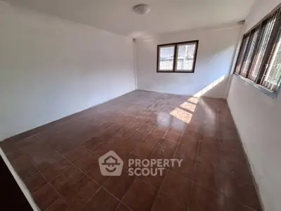 Spacious empty room with tiled floor and large windows, perfect for customization.