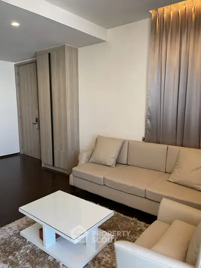Modern living room with beige sofa and sleek coffee table in a stylish apartment.