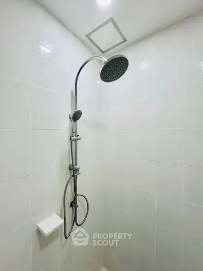 Modern bathroom shower with sleek design and white tiled walls.