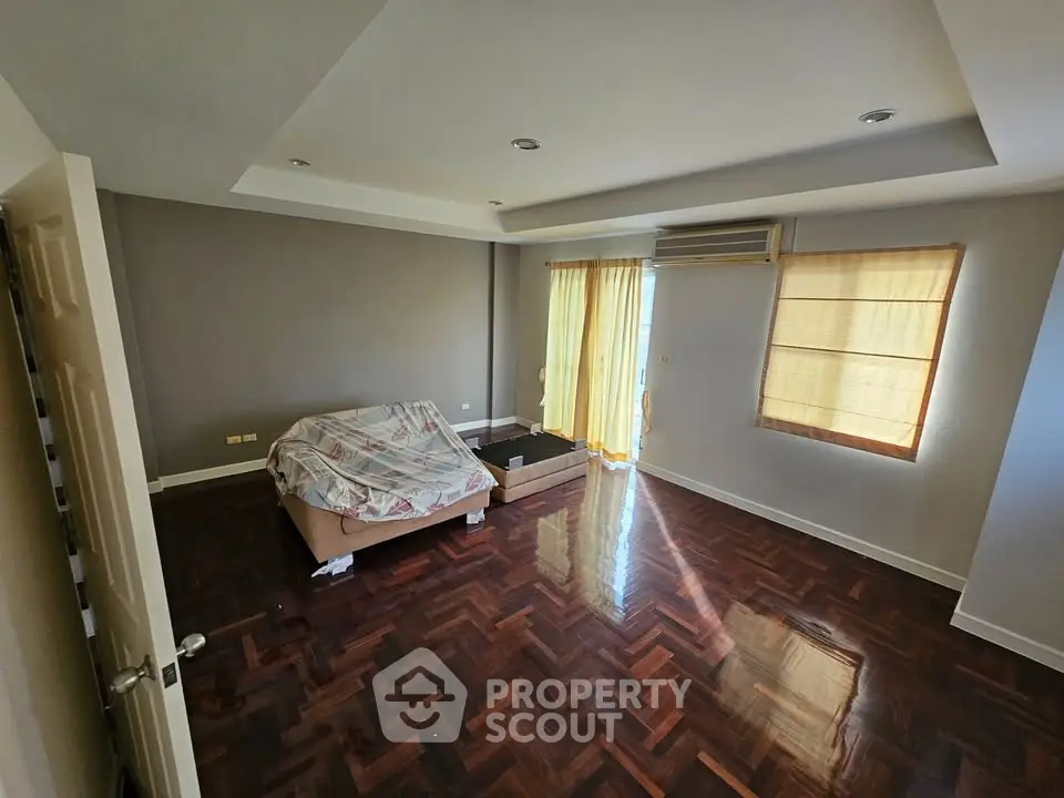 Spacious living room with hardwood floors and natural light