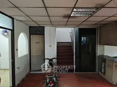 Spacious interior with staircase and storage area, ideal for versatile use.