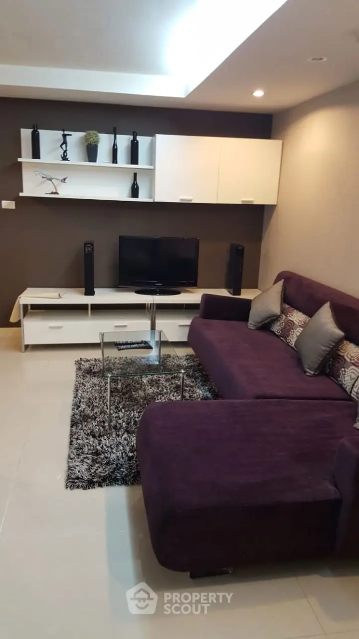 Modern living room with purple sofa and sleek entertainment unit