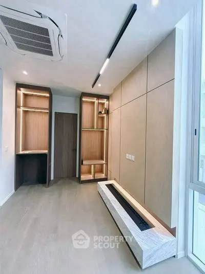 Modern minimalist living room with built-in shelves and sleek lighting