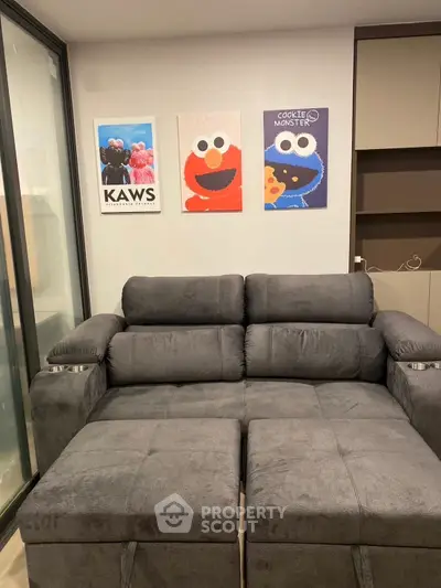 Modern living room with plush gray sofa and playful wall art