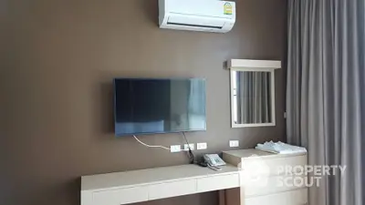 Modern minimalist bedroom with sleek wall-mounted TV, air conditioning unit, and elegant neutral-toned decor.