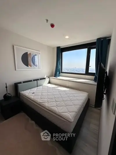 Modern bedroom with large window and stylish decor in high-rise apartment.