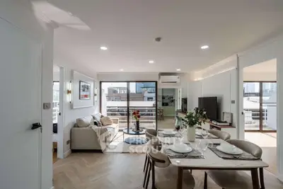 Spacious modern living and dining area with balcony view in a stylish apartment.