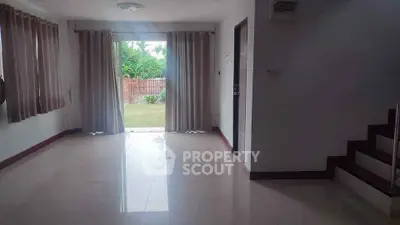 Spacious living room with garden view and elegant staircase