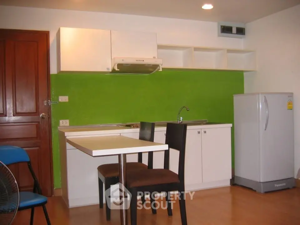 Modern kitchen with vibrant green backsplash and sleek white cabinets