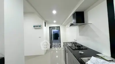 Modern kitchen with sleek design and gas stove in a contemporary apartment.