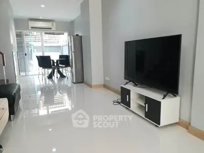 Modern living room with sleek TV setup and dining area, perfect for contemporary living.