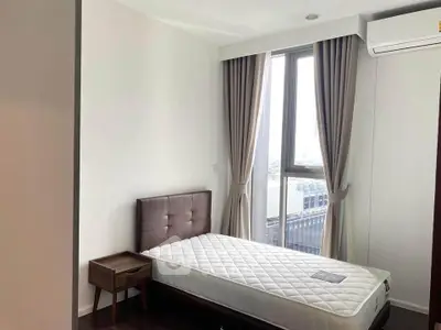 Modern bedroom with large window and air conditioning in a stylish apartment.