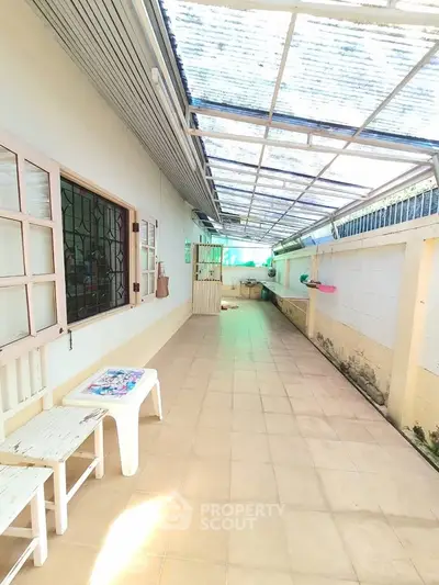 Spacious covered outdoor area with tiled flooring and natural light