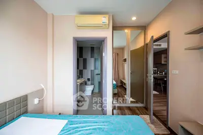 Modern bedroom with ensuite bathroom and air conditioning in stylish apartment.